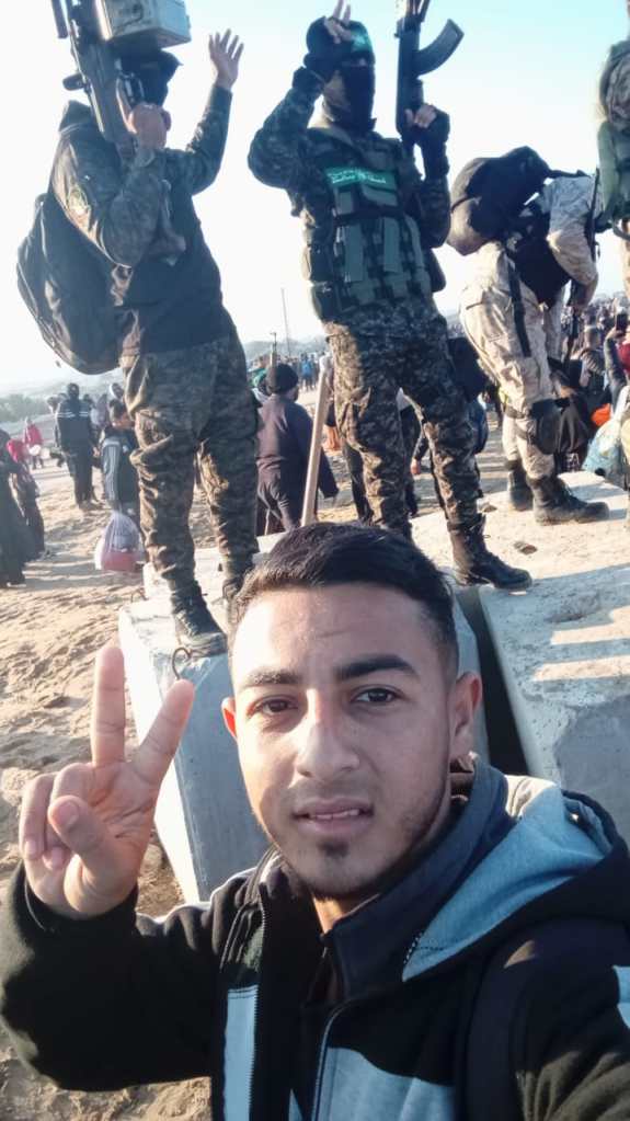 Muhammad walking home to Gaza City and giving the peace sign, among a crowd of displaced Palestinians and armed resistance fighters
